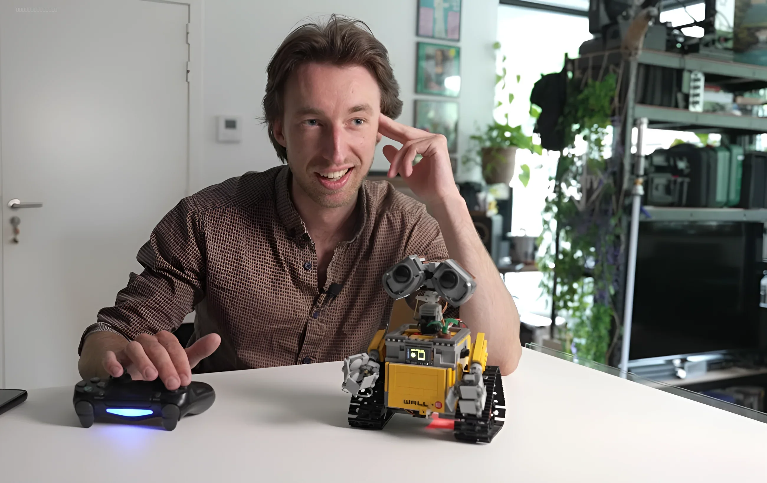 Человек управляет роботом WALL-E из LEGO с помощью геймпада PlayStation