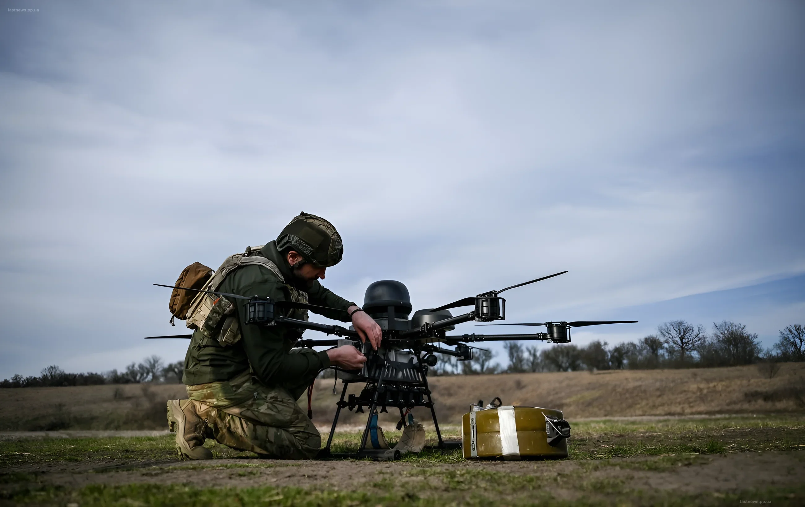 Ukrainian soldier in camouflage preparing a large military drone for launch in an open field
