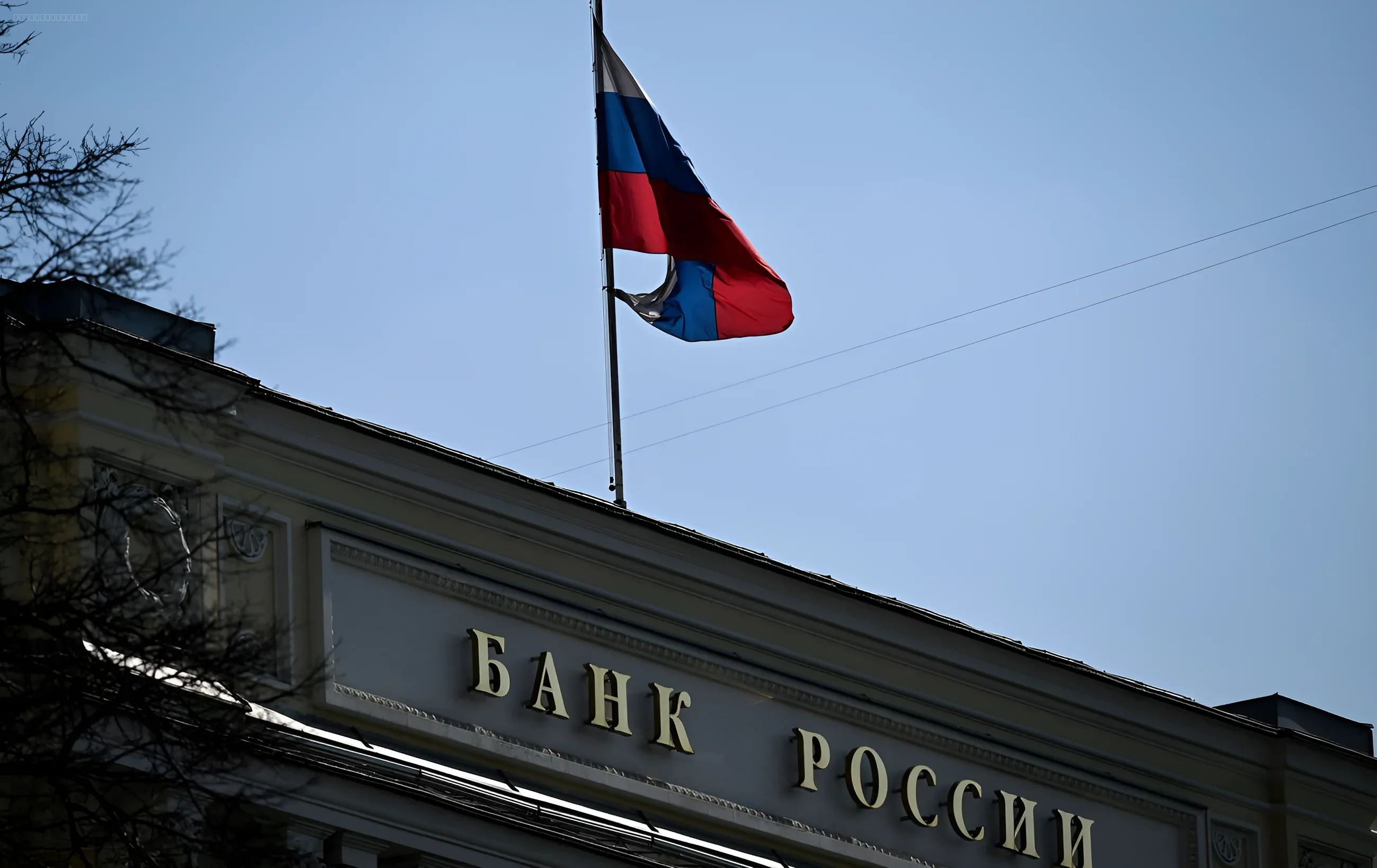 Флаг России над зданием Центрального банка РФ на фоне ясного неба