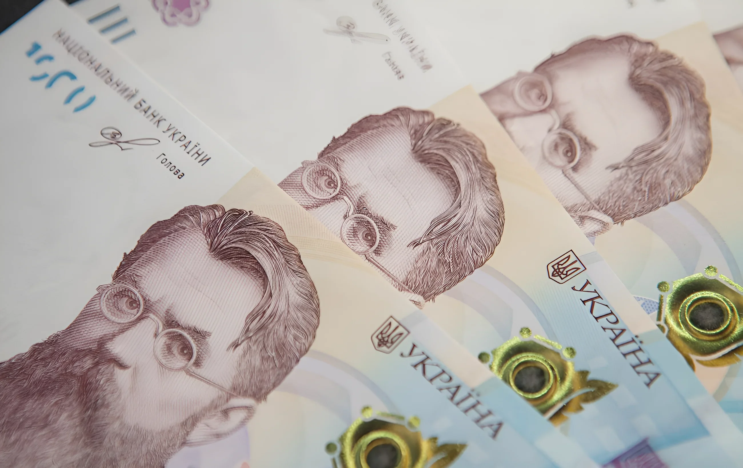 Украинские гривны с портретами исторических личностей, символизирующие пенсионные выплаты и экономику