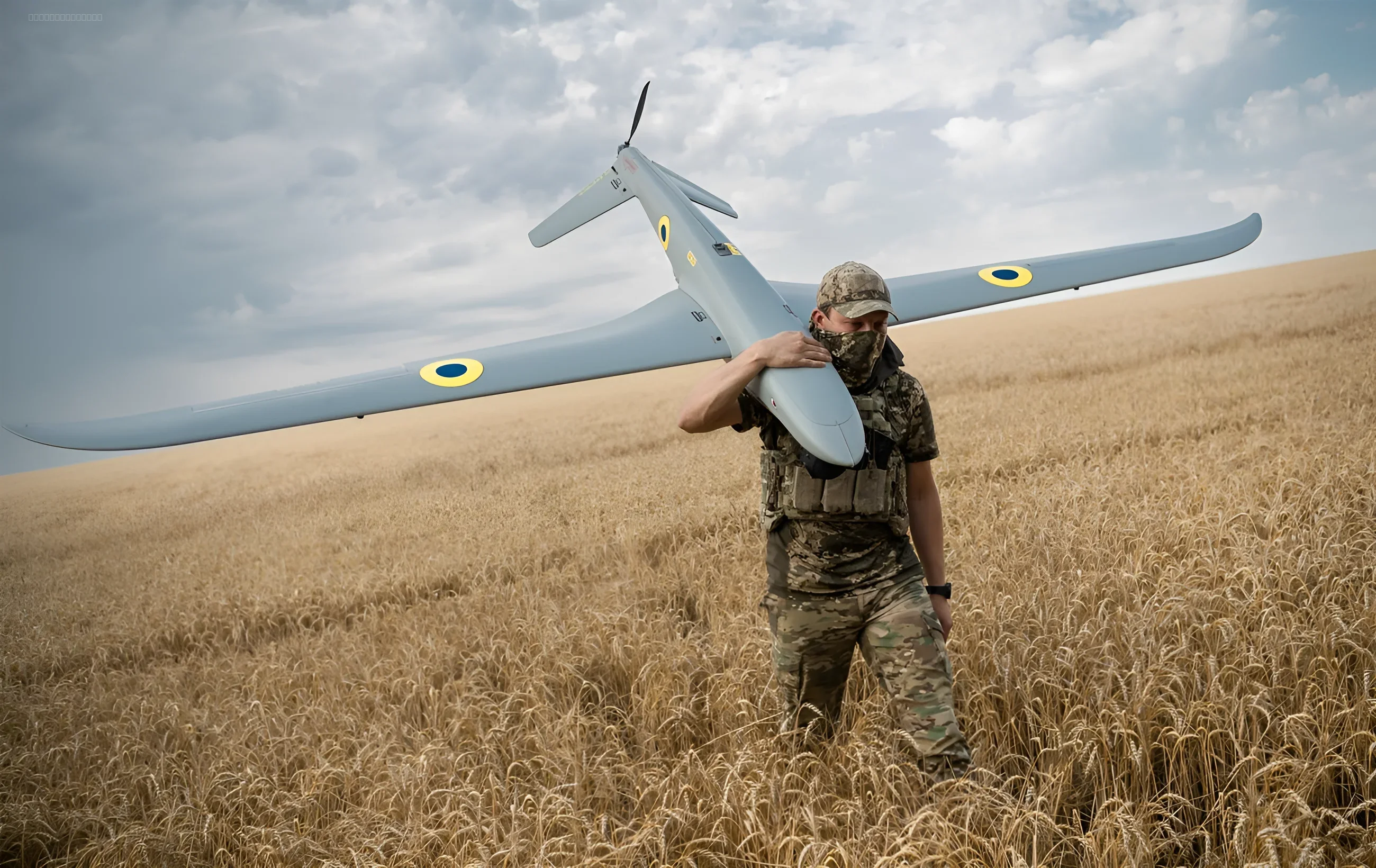 A Ukrainian serviceman carrying a drone on his shoulder in a field, symbolizing the SOF's secret "strike wings"