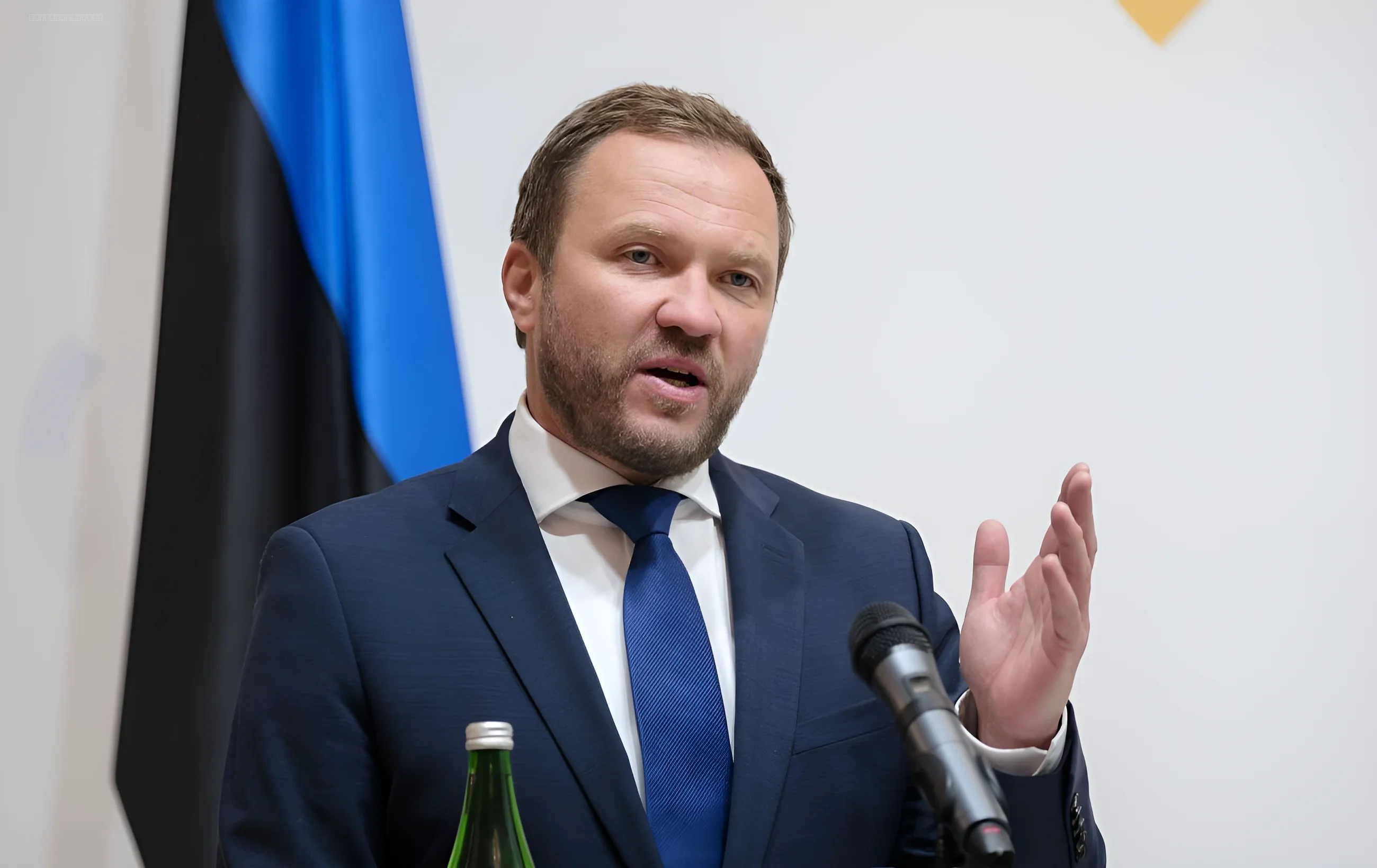 Министр иностранных дел Эстонии Маргус Тсаакна выступает с речью на фоне государственного флага, объясняя стратегию ЕС по санкциям