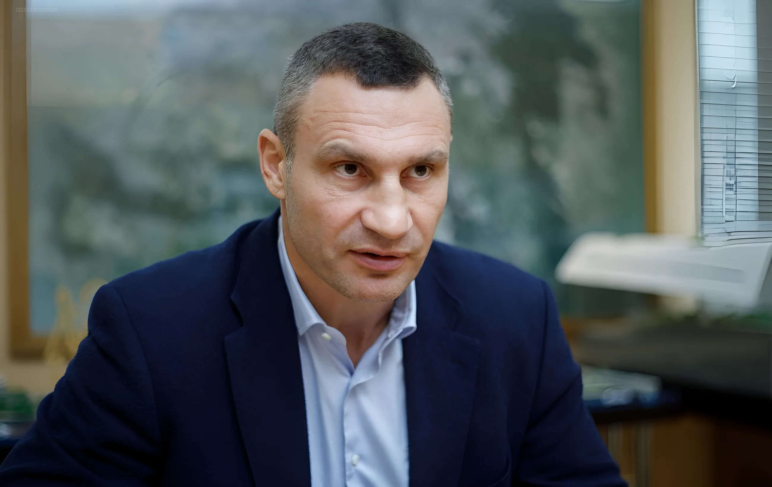 Виталий Кличко, действующий мэр Киева, обсуждает вопросы управления городом на фоне оконного проема