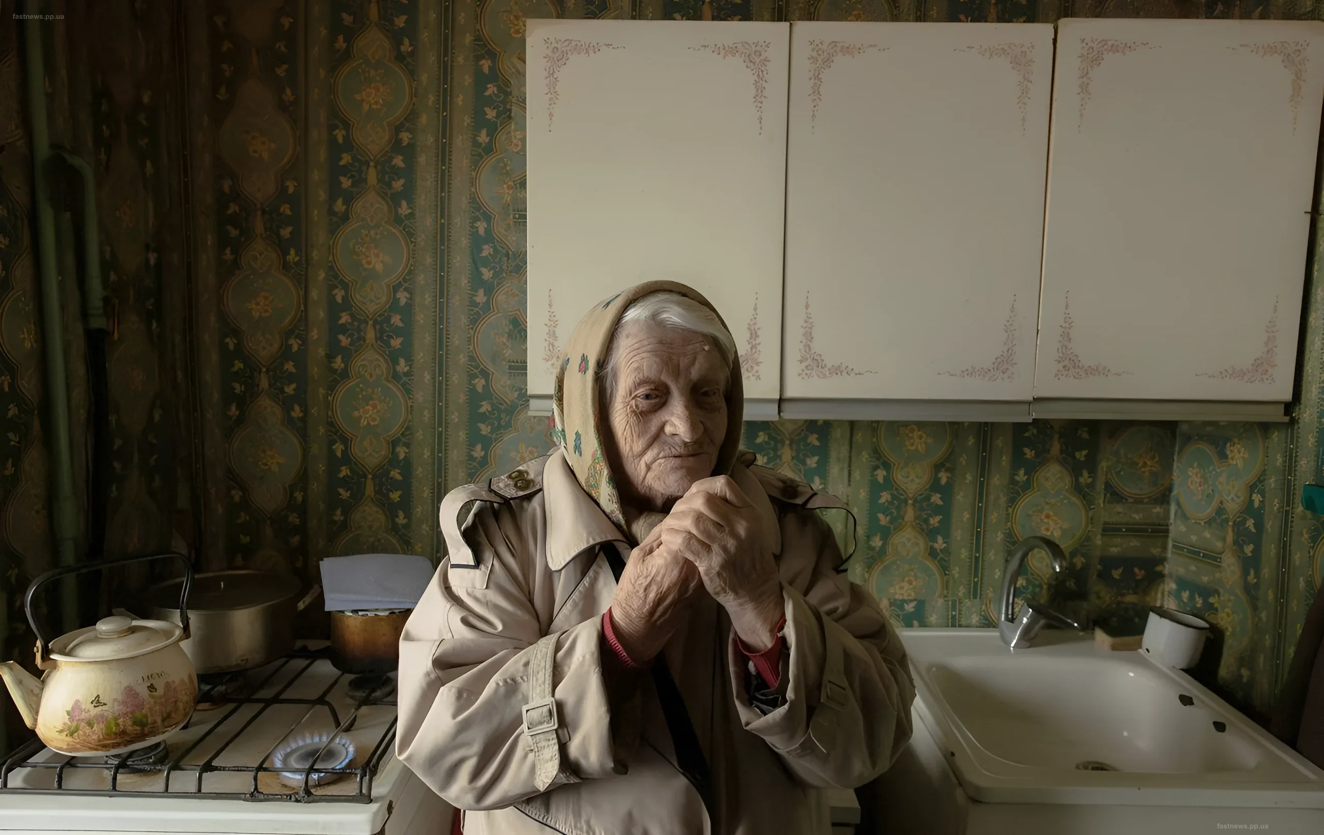 Elderly woman in a kitchen in an old house, symbolizing the difficulties of winter preparation in Kyiv