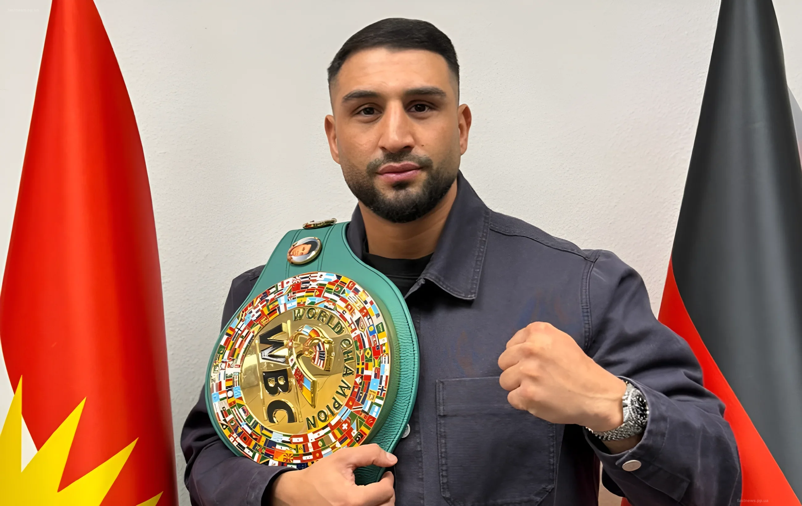 Агит Кабаел держит пояс WBC на фоне флагов, демонстрируя готовность к бою с Усиком