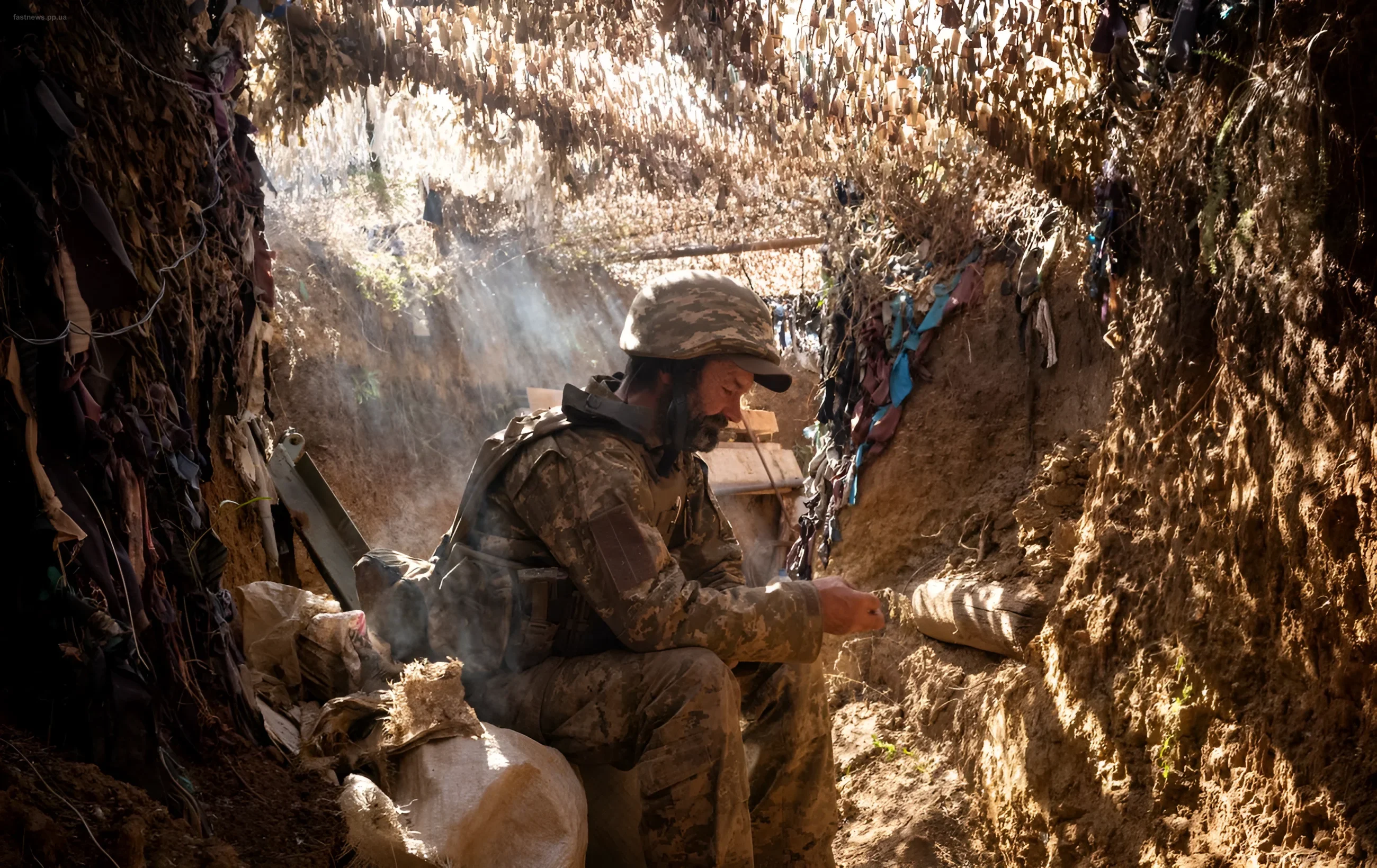 Ukrainian soldier in a trench under Kharkiv, surrounded by defensive structures and camouflage netting