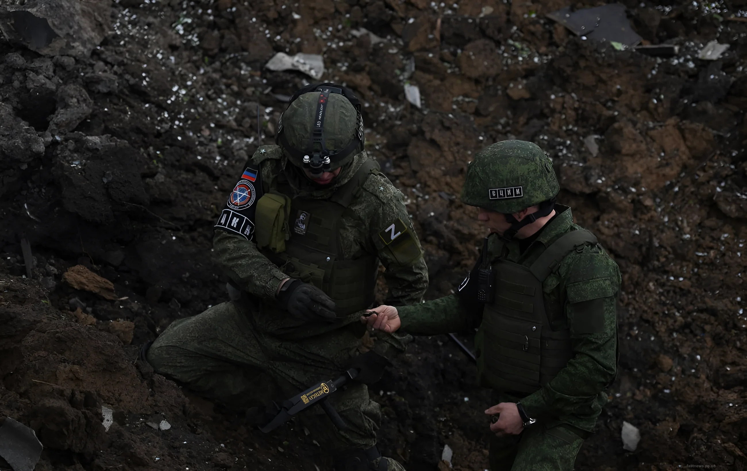 Russian soldiers with the "Z" identifier in a trench, discussing the tactical situation against a backdrop of destruction