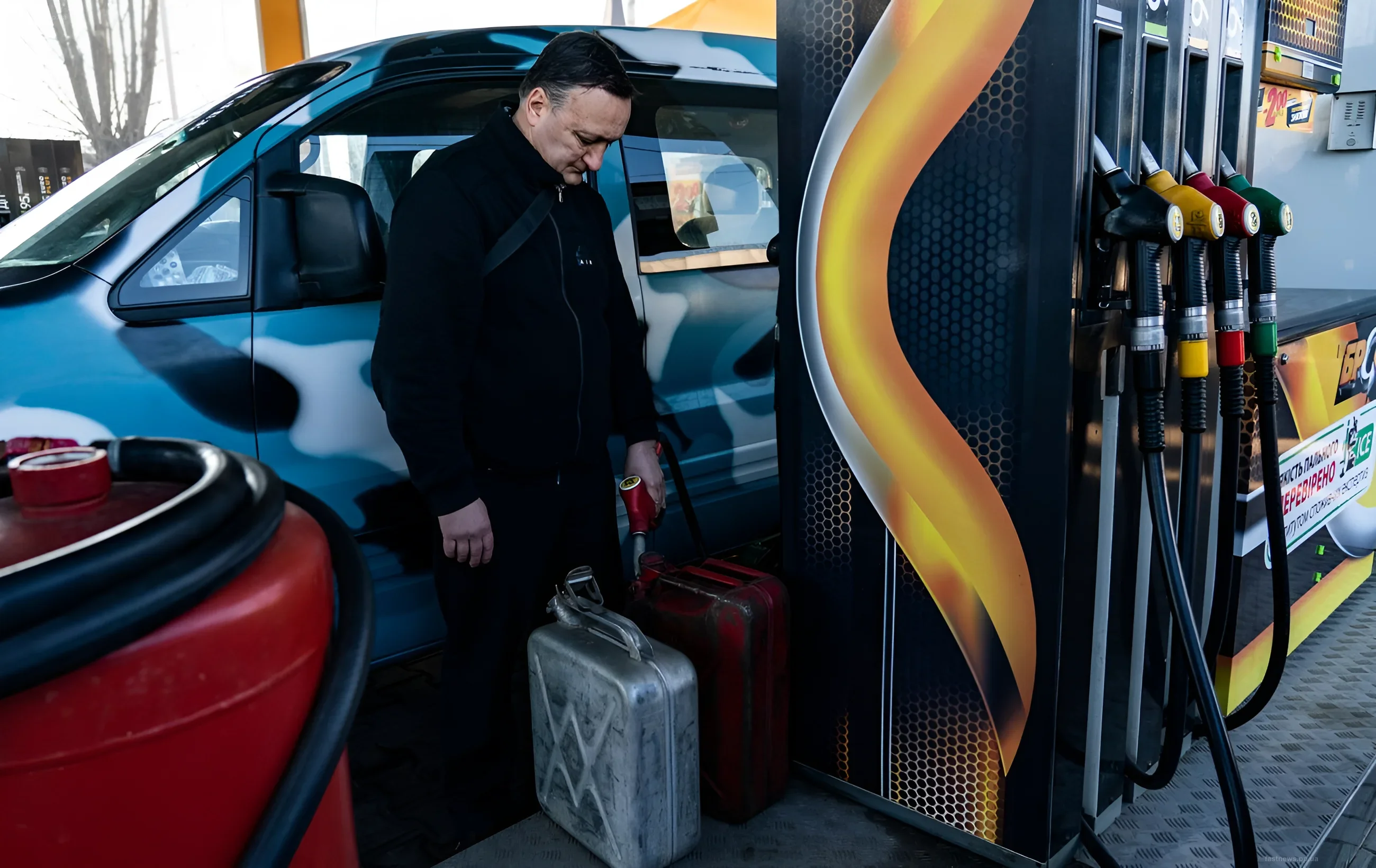 A man fills jerry cans with gasoline at a gas station amid a fuel shortage in Sevastopol
