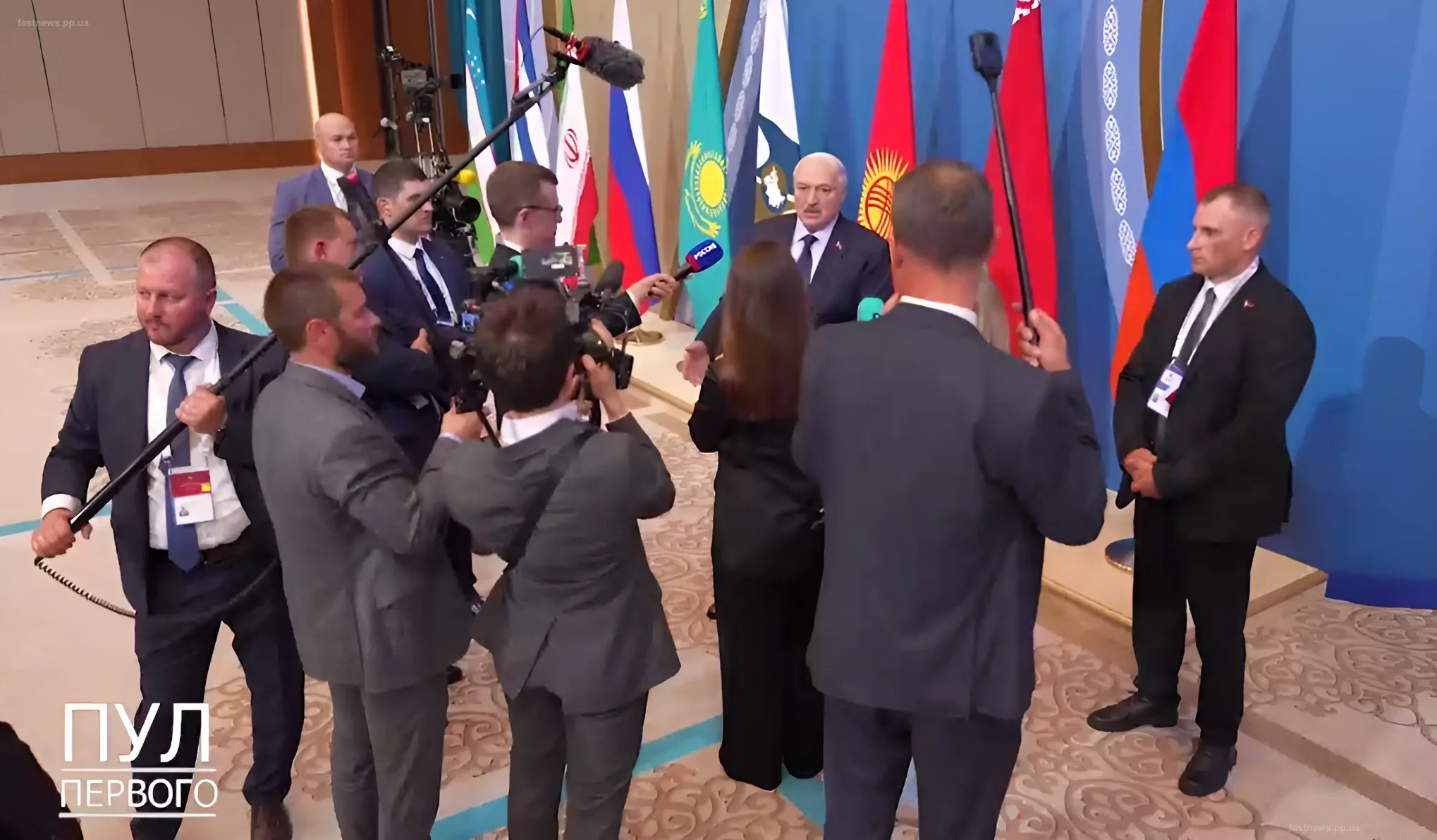 Alexander Lukashenko at a press conference with flags of partner countries in the background