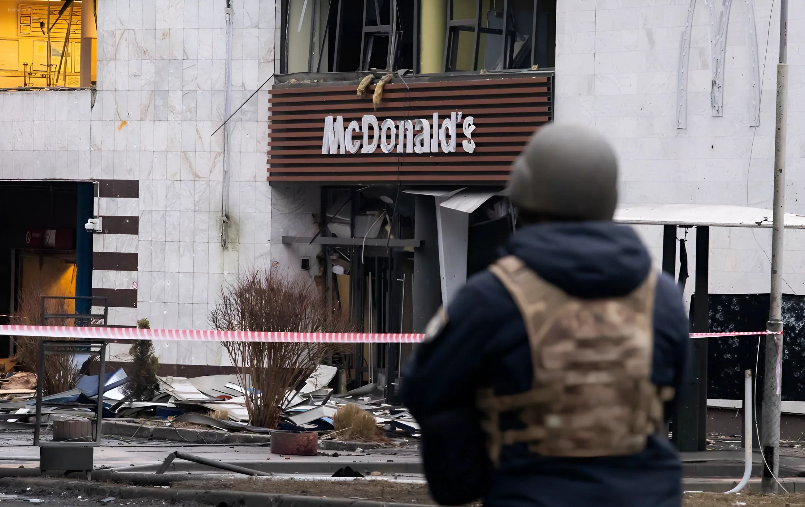 Destroyed facade of a building with a McDonald's sign against the backdrop of war destruction in Kyiv