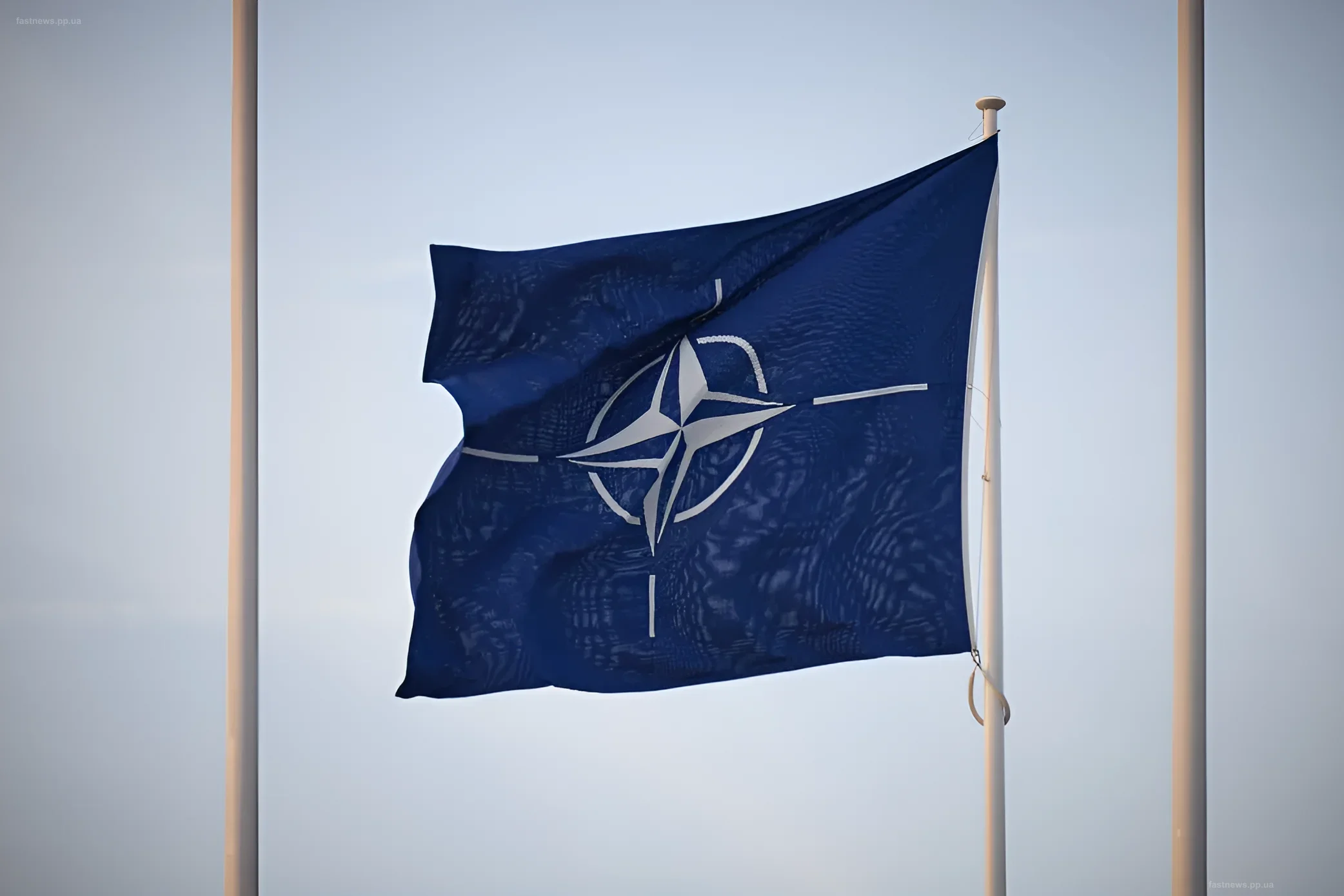 NATO flag waving against a clear sky, symbolizing unity and readiness to protect allies following the Russian drone incident in Romania