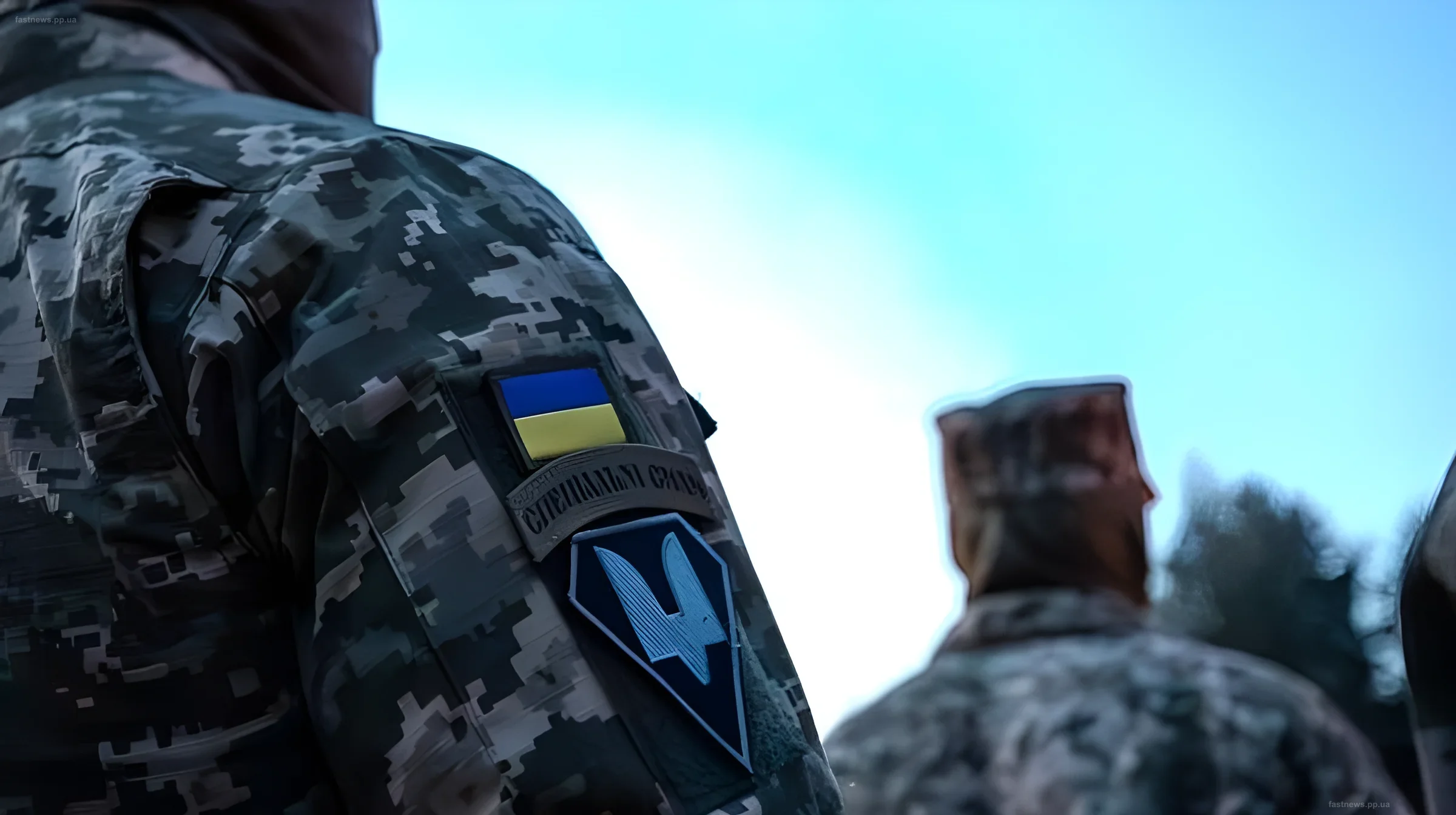 Украинские военные ССО с нашивками на рукавах на фоне неба