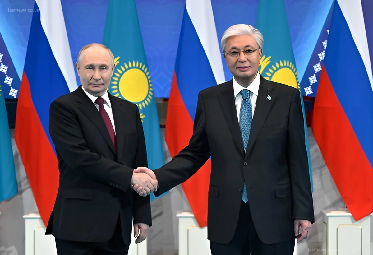Владимир Путин и Касым-Жомарт Токаев пожимают руки на фоне флагов России и Казахстана во время официального визита в Астане