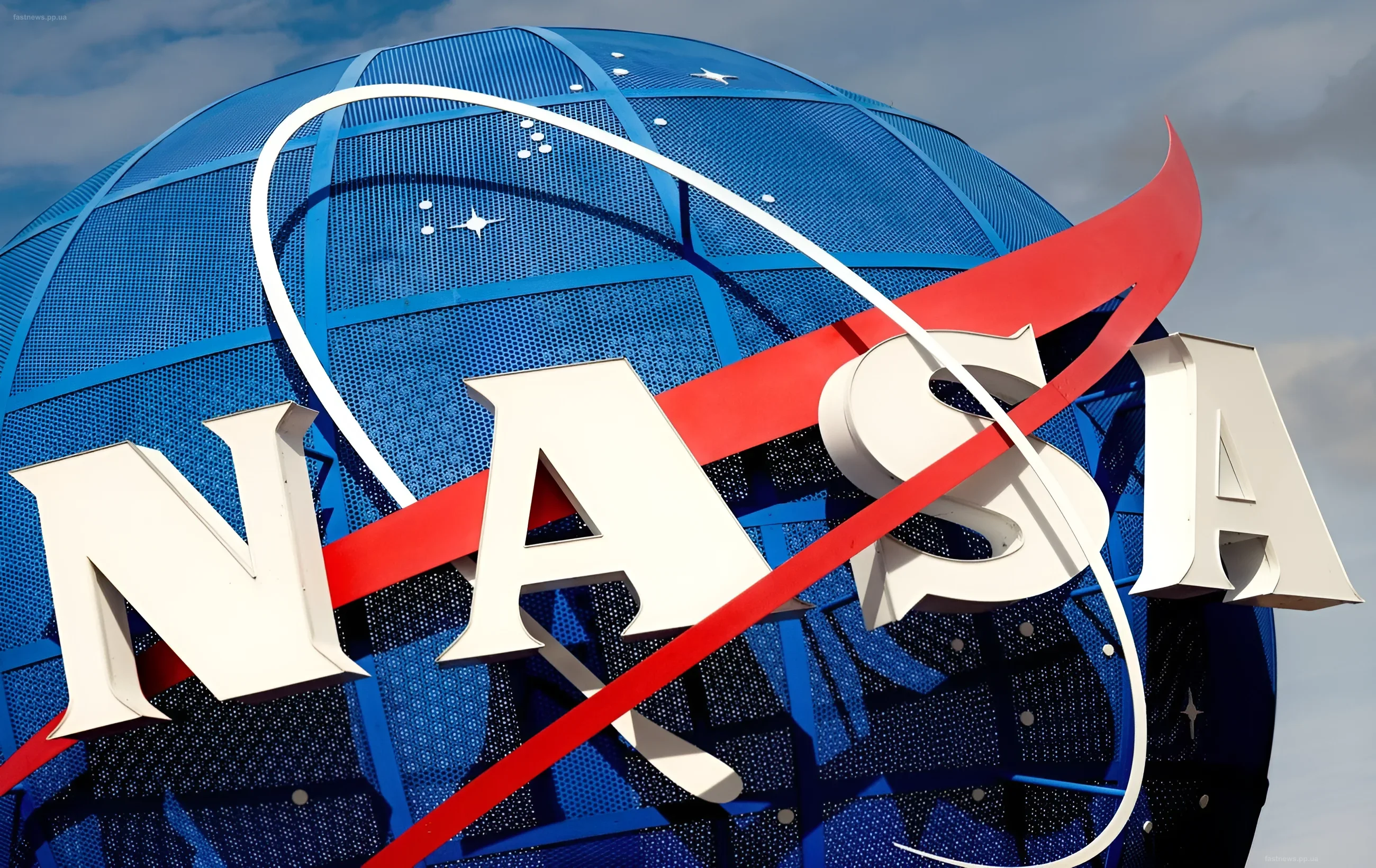Крупный план логотипа NASA на синем металлическом глобусе, символизирующий космические технологии и спутниковый мониторинг