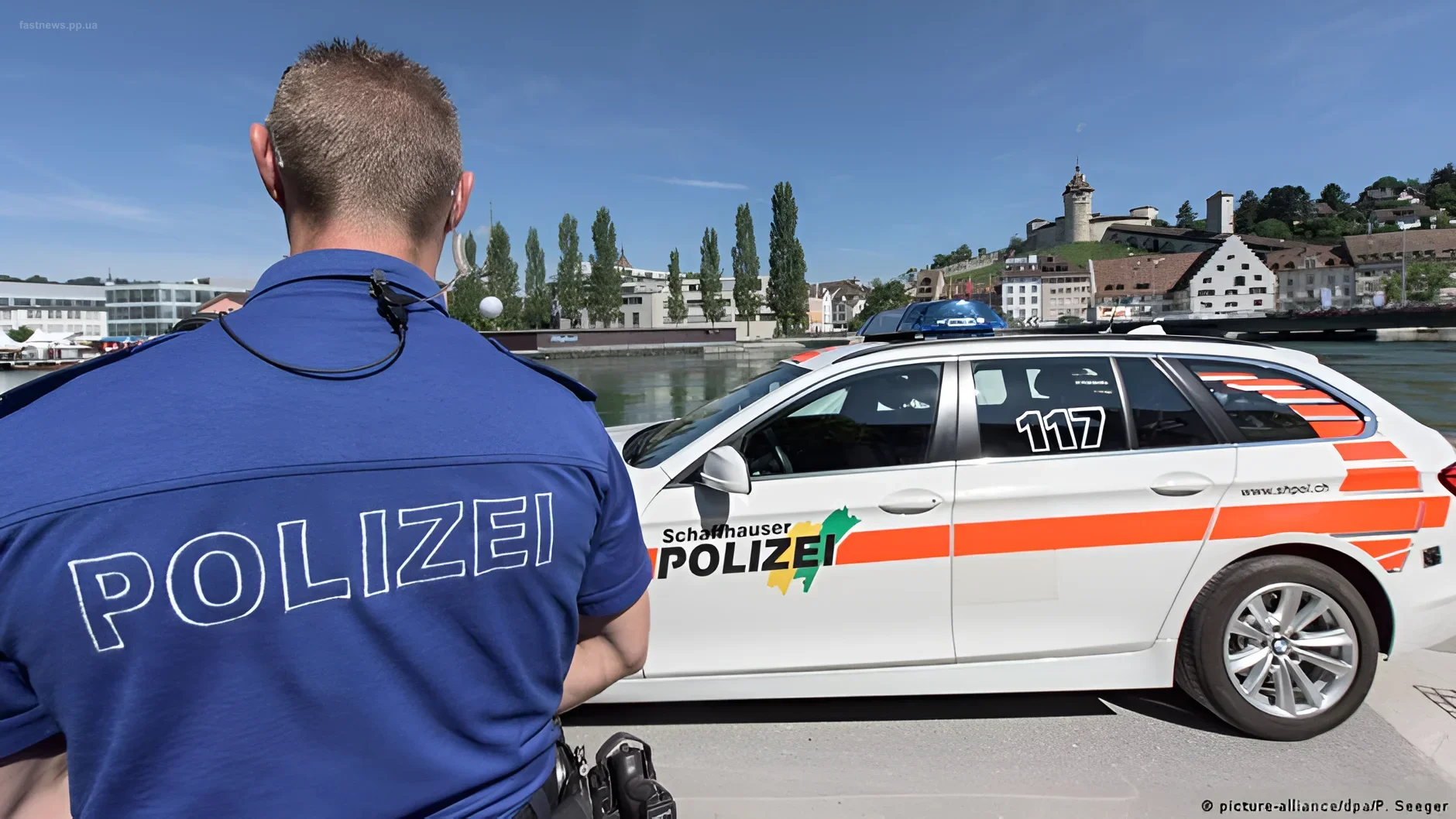 Швейцарский полицейский и патрульный автомобиль на фоне реки и города Шaffhausen