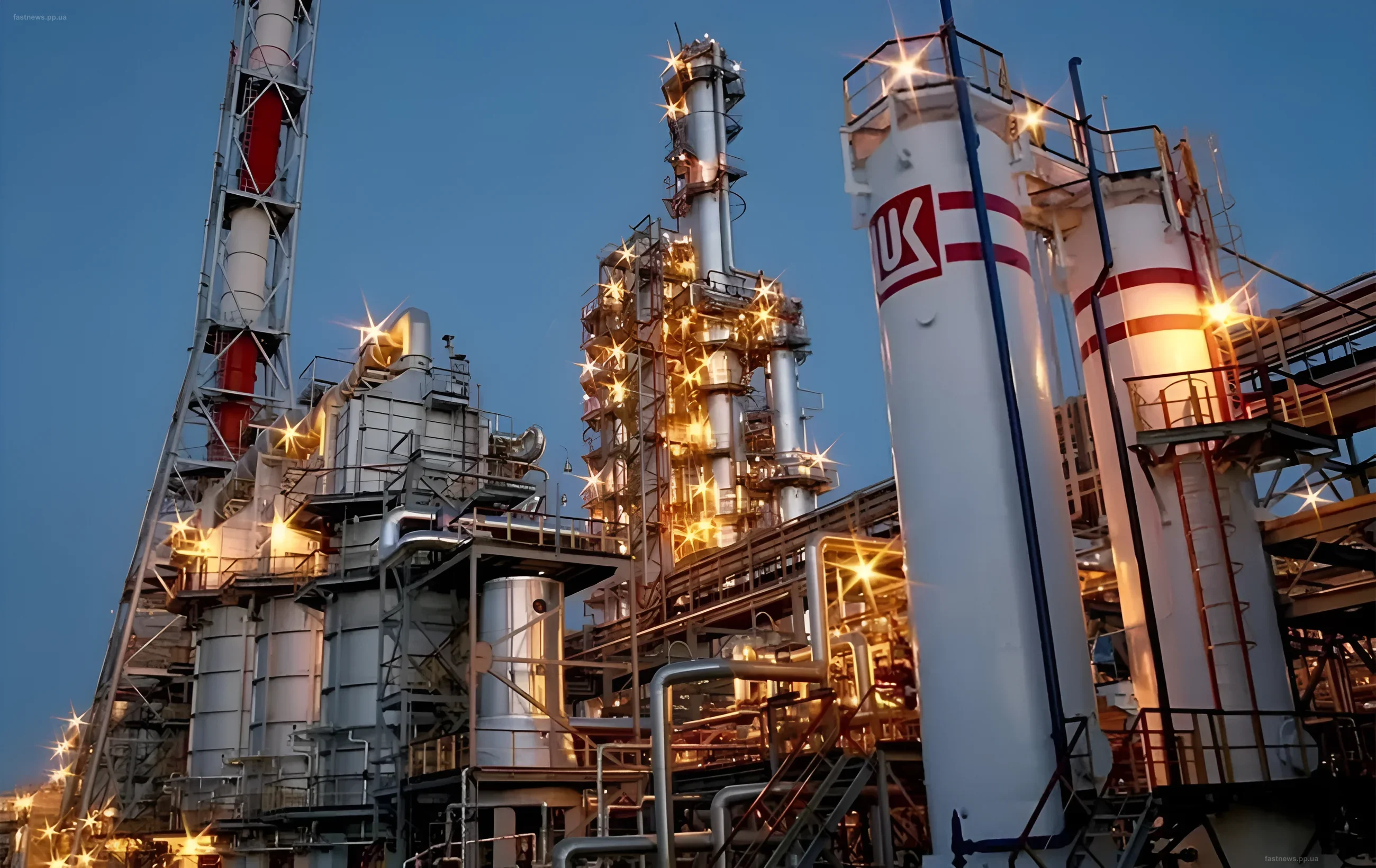 Ночной вид на нефтеперерабатывающий завод с горящими резервуарами и огнями прожекторов