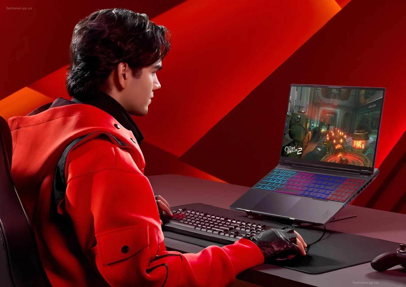 Геймер в красной куртке играет на ноутбуке Acer Nitro 16 с подсветкой клавиатуры