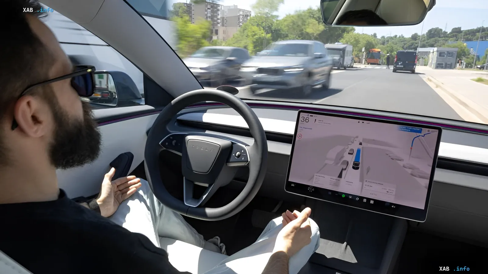 Водитель в Tesla с включенным FSD, руки оторваны от руля, экран показывает карту и окружение, Эстония разрешила автопилот