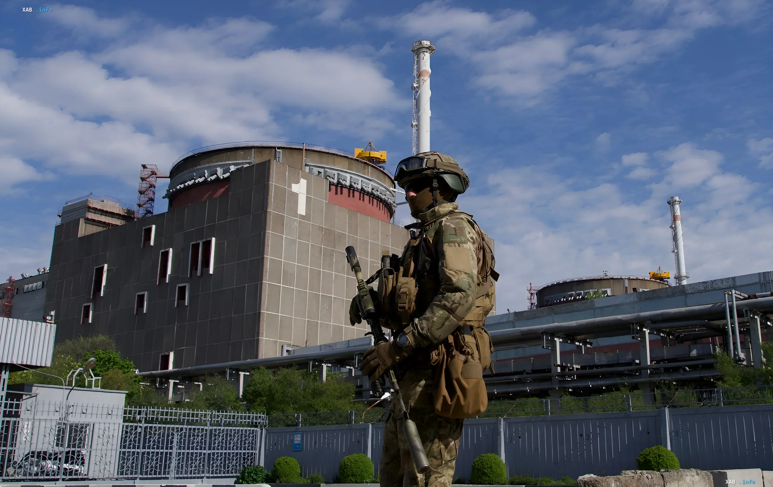 Soldier in camouflage stands in front of the Zaporizhzhia NPP building, symbolizing Russian presence and the threat of nuclear blackmail