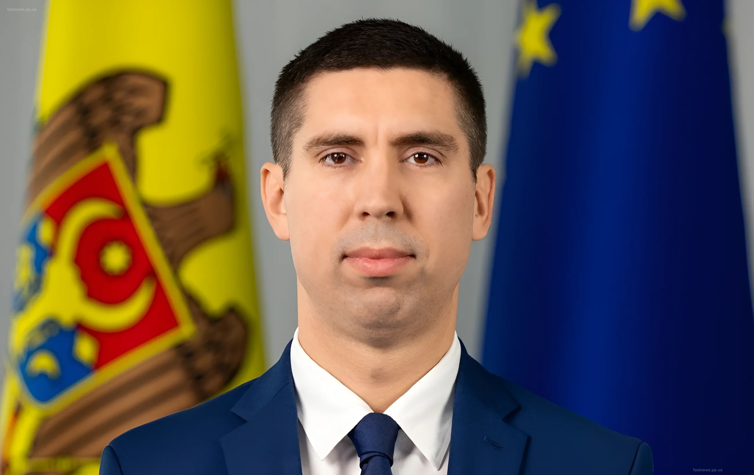 Михай Попшой в деловом костюме перед флагами Молдовы и ЕС — министр обороны обсуждает готовность страны к НАТО