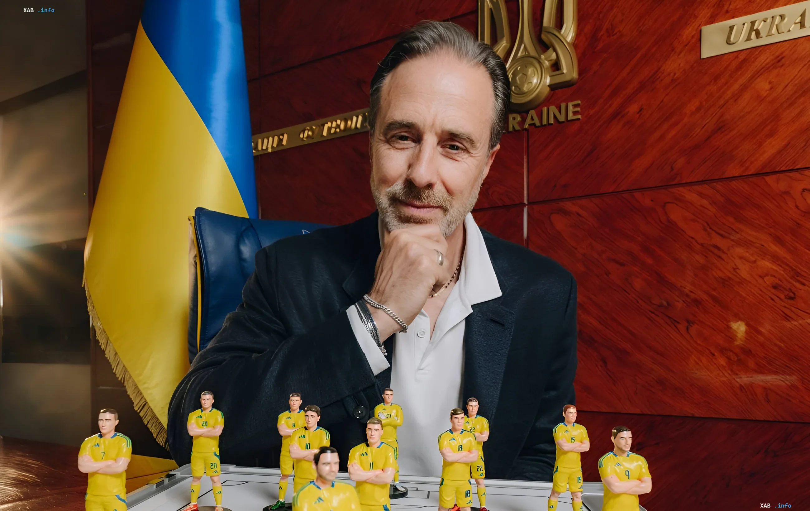 Марко Мальдера за столом с фигурками футболистов сборной Украины в желтой форме, на фоне украинского флага и герба, символизируя начало работы над перестройкой команды