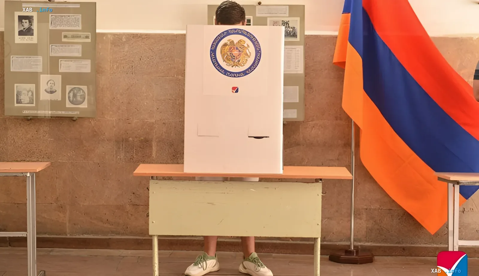 Voting booth in Armenia with the national flag and coat of arms on the ballot box, symbolizing democratic choice and sovereignty