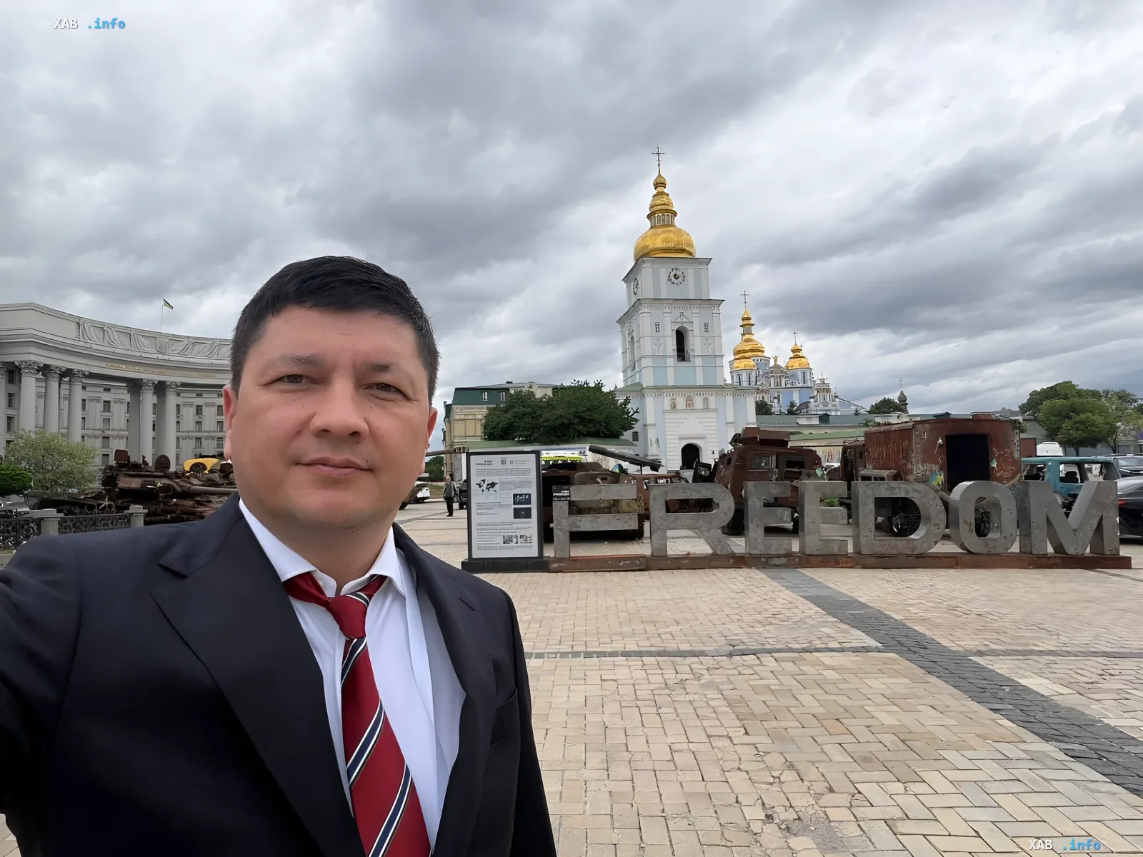 Виталий Ким в деловом костюме на фоне памятника «Свобода» и Софийского собора в Киеве