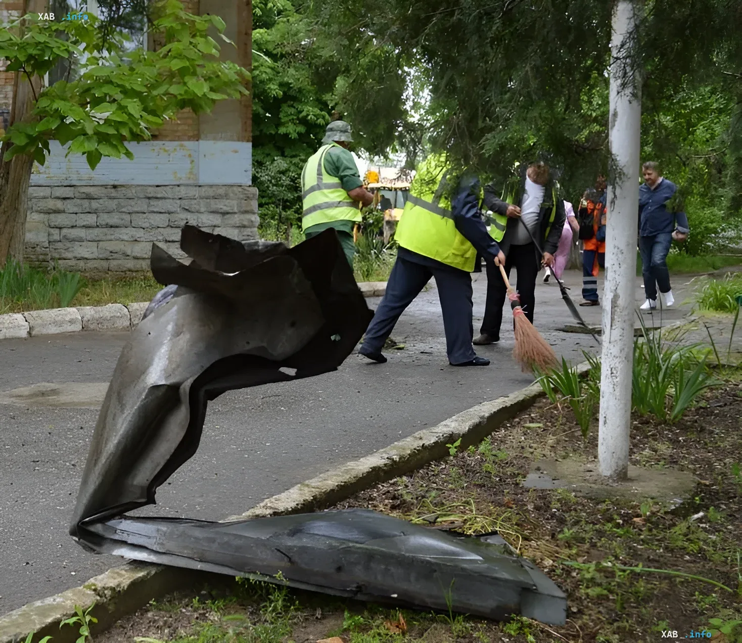 Последствия налета на роддом в Аккермане: разрушения и уборка Поврежденный металлический лист у здания роддома в Аккермане после налета, рядом коммунальщики убирают территорию