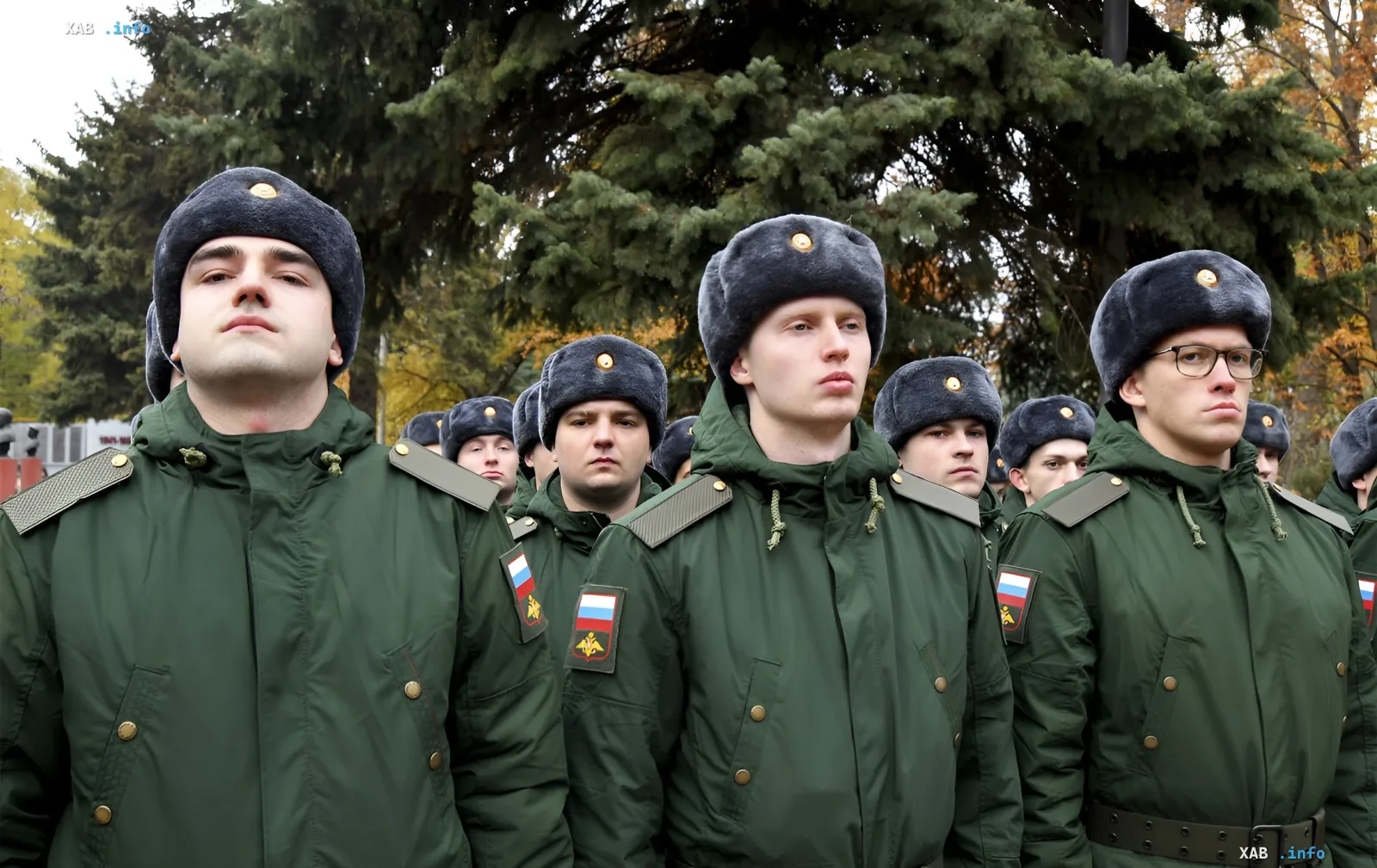 Russian military personnel in winter uniforms stand in formation against a backdrop of autumn trees, symbolizing readiness for a new wave of mobilization and a northern strike scenario
