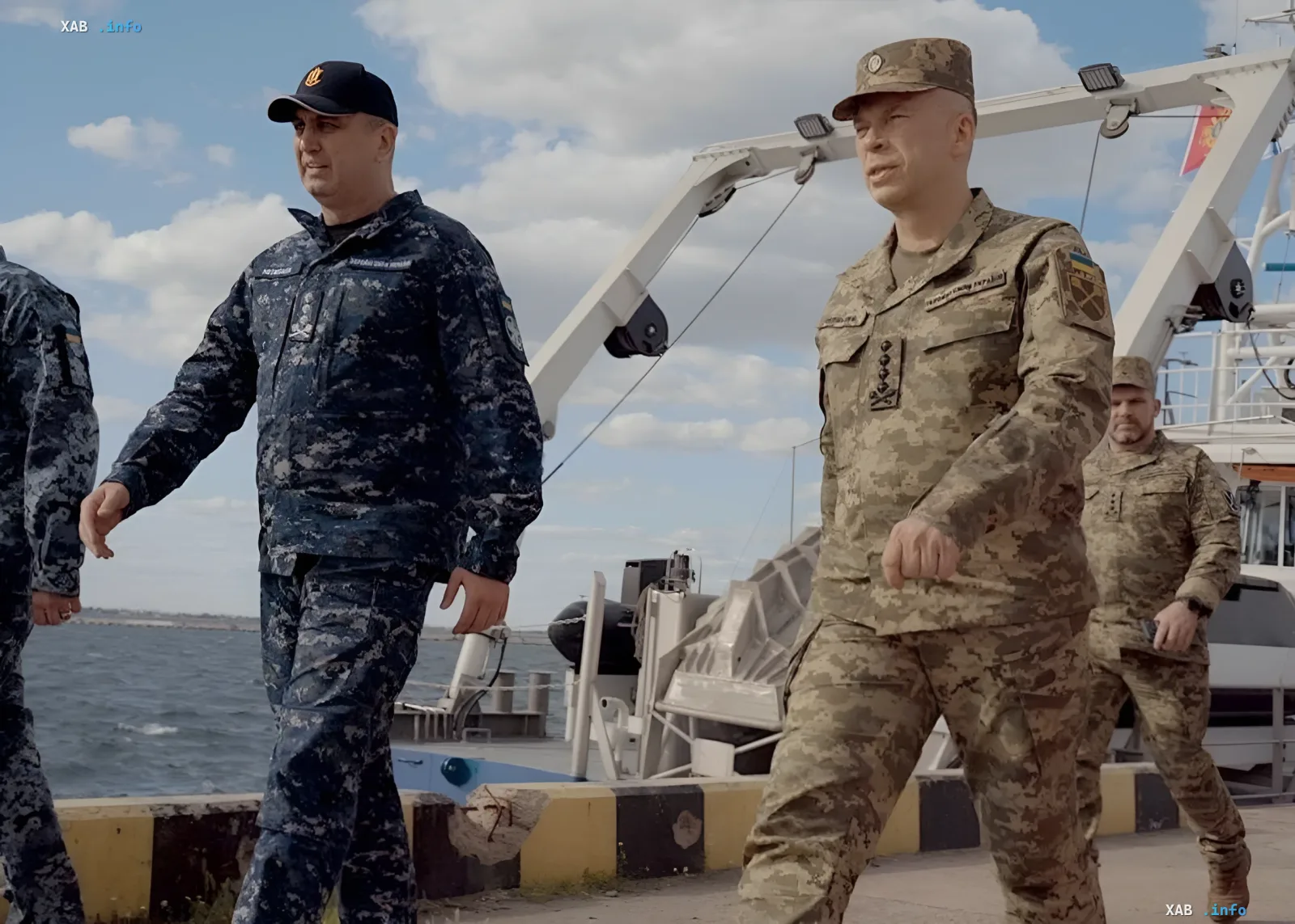 Украинские военные в камуфляжной форме на палубе корабля на фоне морской операции