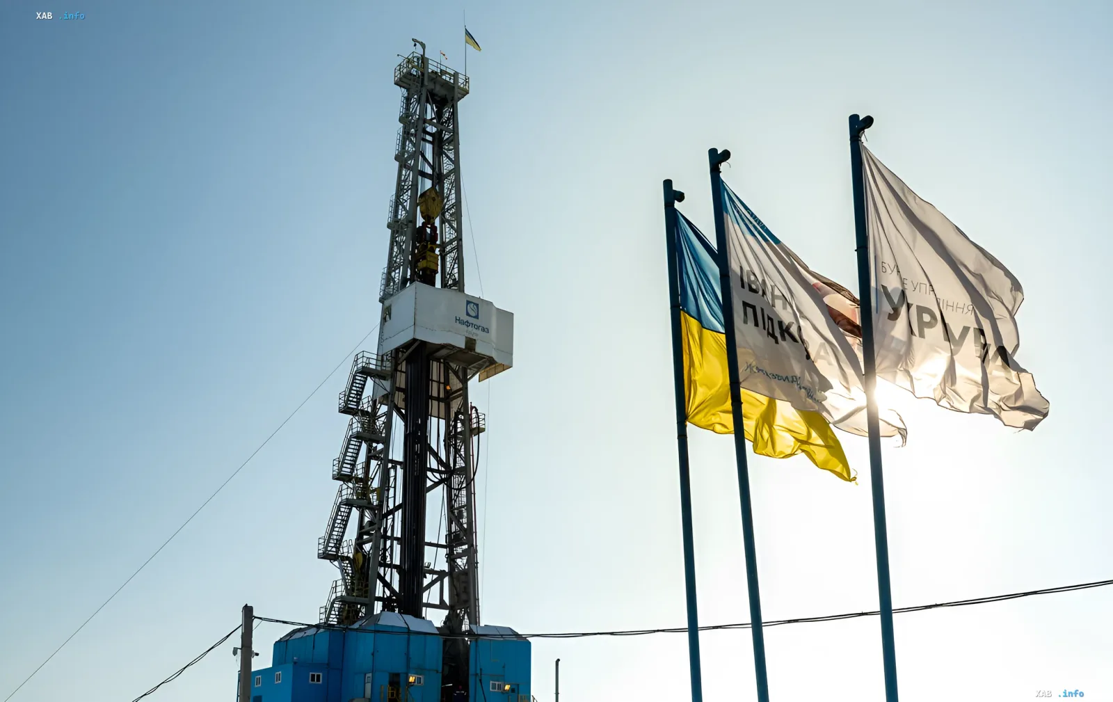 Naftogaz drilling rig with Ukrainian flag and corporate banners against clear sky — symbol of Ukraine’s energy sovereignty
