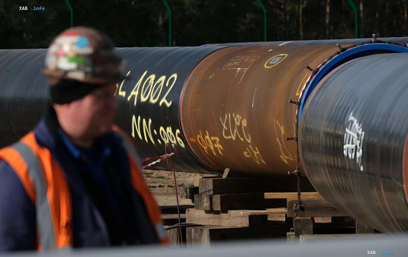 Рабочий в каске и жилете у газовых труб на стройплощадке, символизирующий инфраструктуру поставок газа Газпрома в Турцию после 2026 года