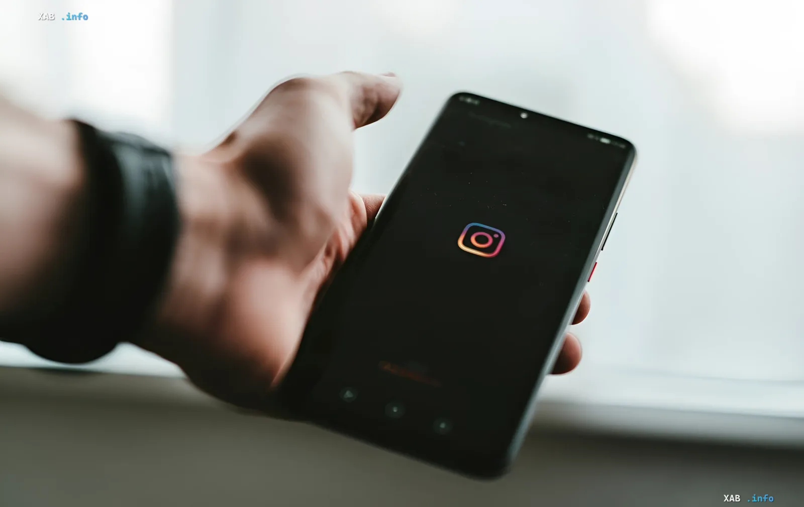 Человек держит смартфон с логотипом Instagram, символизируя уязвимость Meta, через которую обычные фразы в чате с ИИ привели к взлому страниц Белого дома