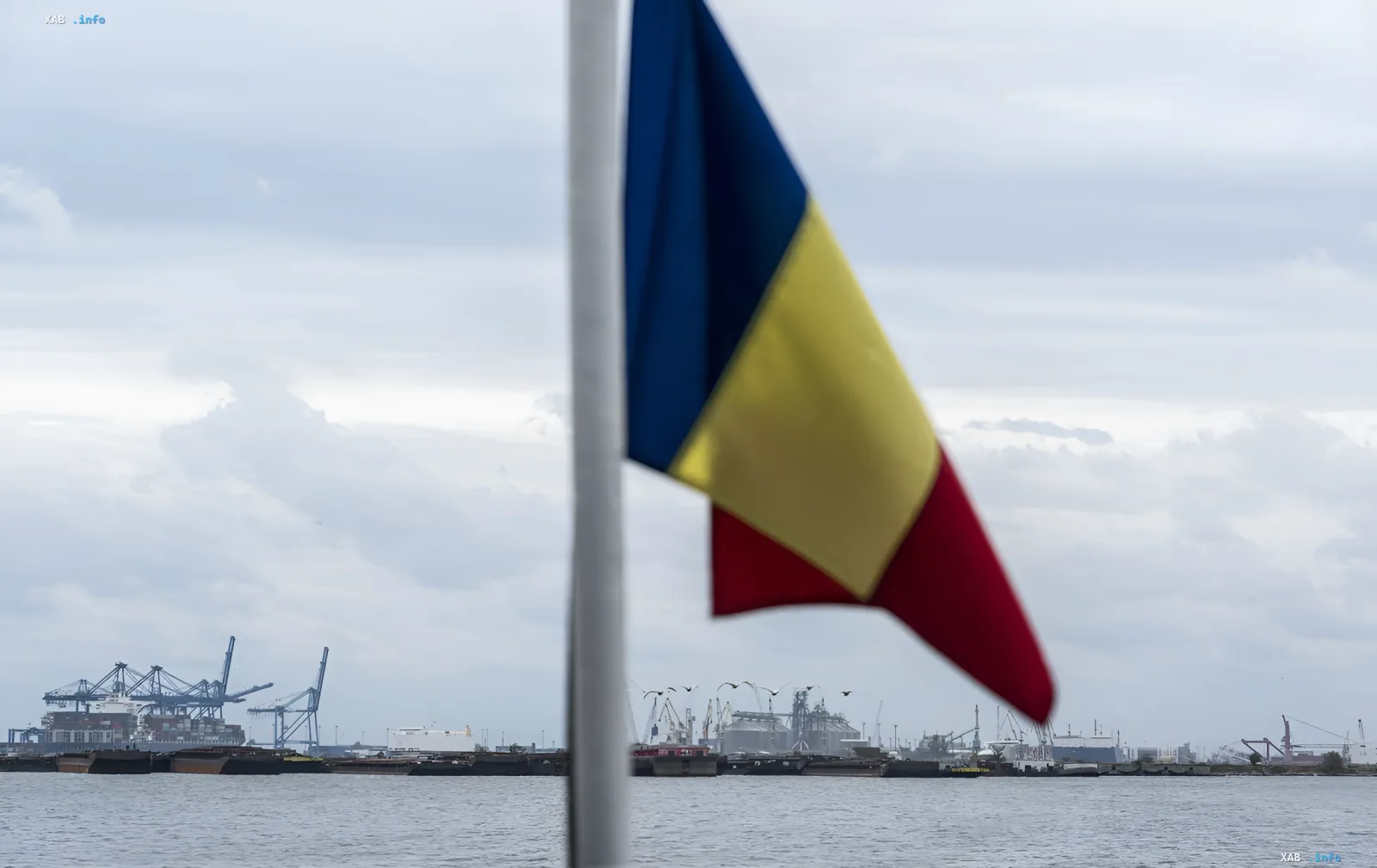 Flag of Romania against a port backdrop, symbolizing potential unification with Moldova