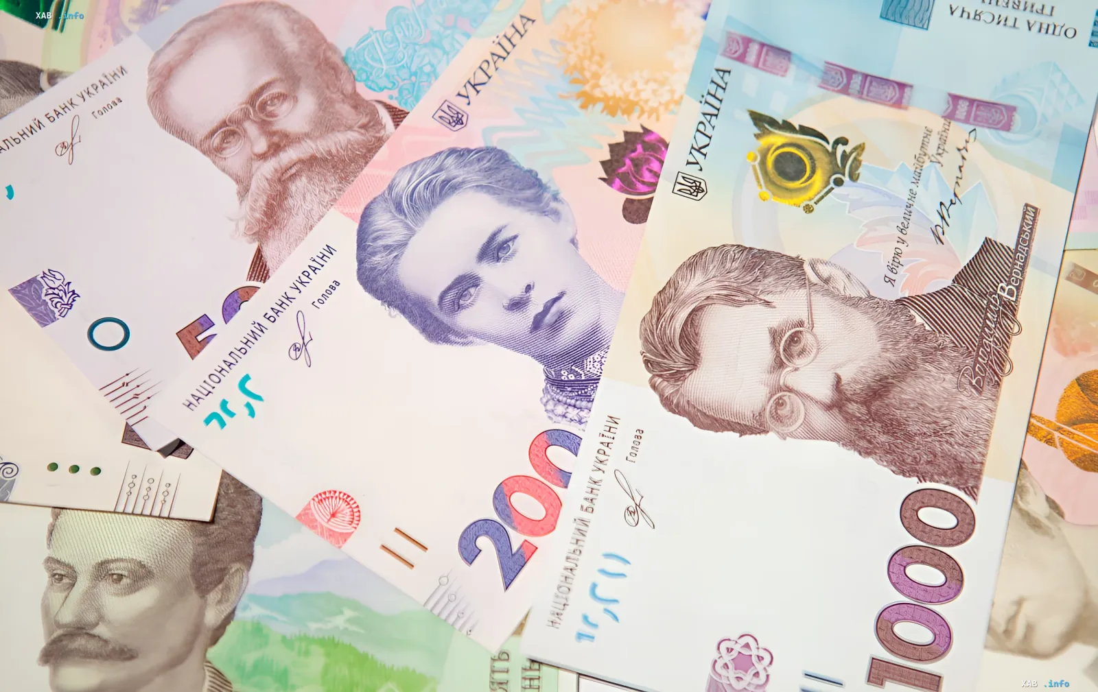 Крупный план украинских банкнот номиналом 100, 200 и 1000 гривен, иллюстрирующий тему наличности и отчет НБУ