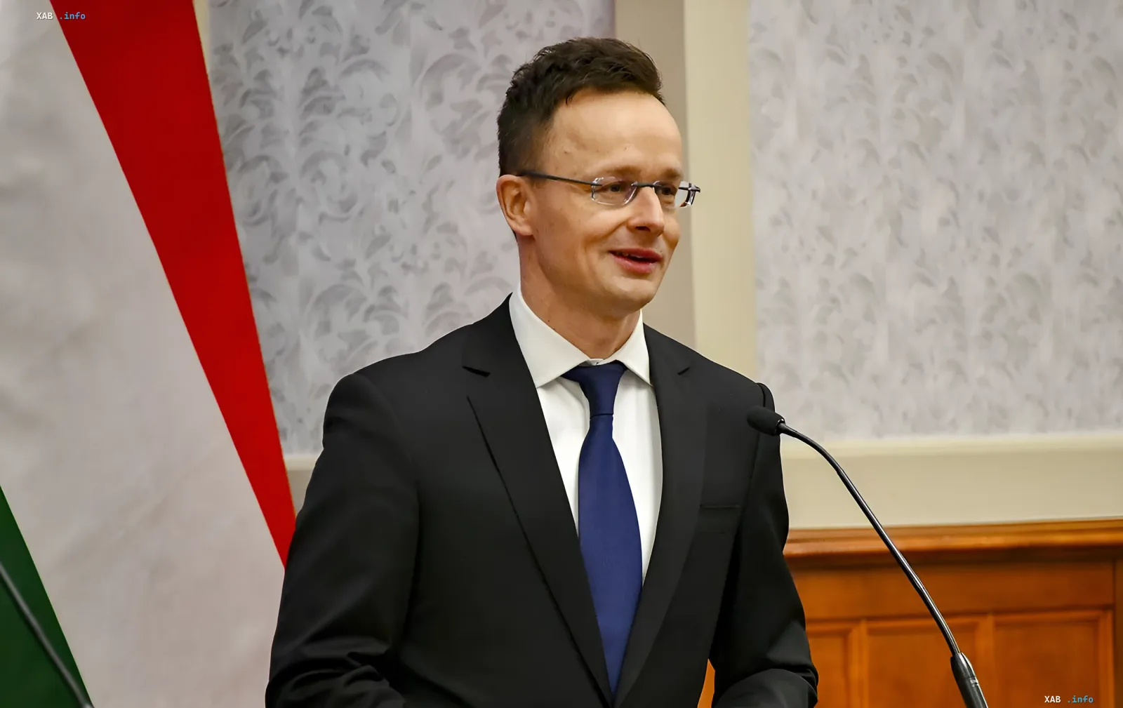 Министр иностранных дел Венгрии на пресс-конференции на фоне венгерского флага, в контексте массовых отставок в МИД