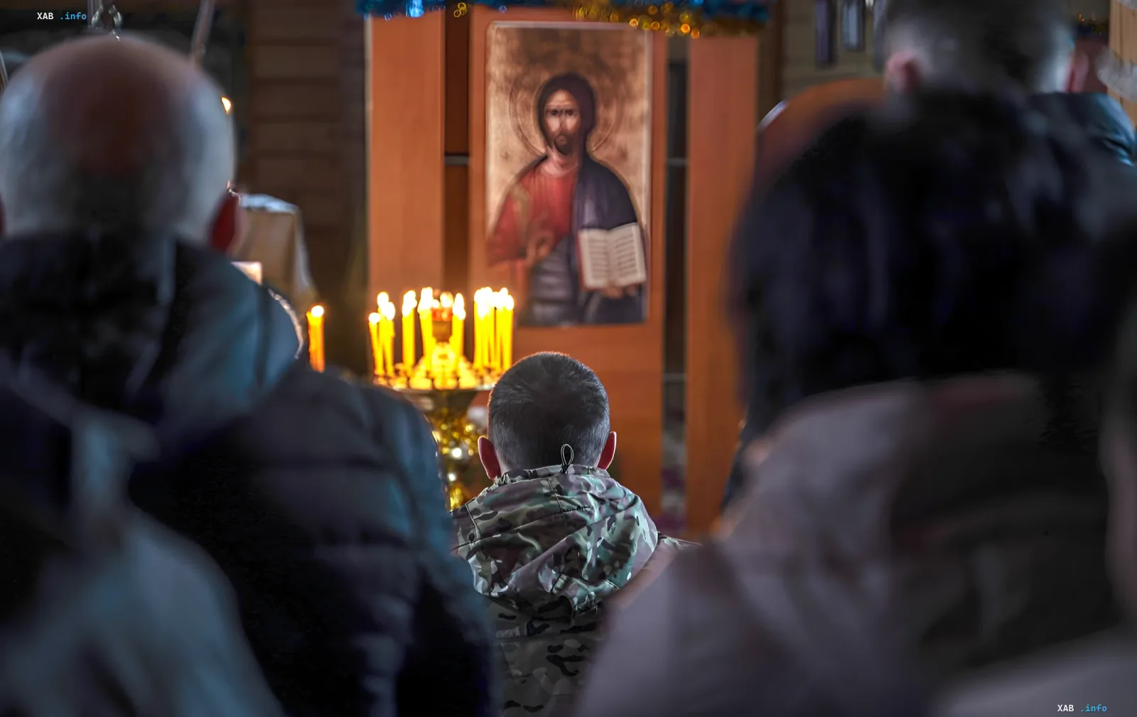 Gläubige beten vor einer Ikone von Jesus Christus in einer Kirche, was die Rolle der Religion im Leben der Ukrainer gemäß den Ergebnissen einer Vertrauensumfrage symbolisiert