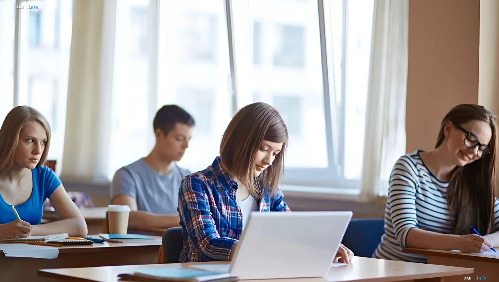 Studenten im Klasszimmer arbeiten an Laptops und machen Notizen, was das Thema der Überprüfung von Stipendien in Odessa aufgrund der Inflation illustriert.