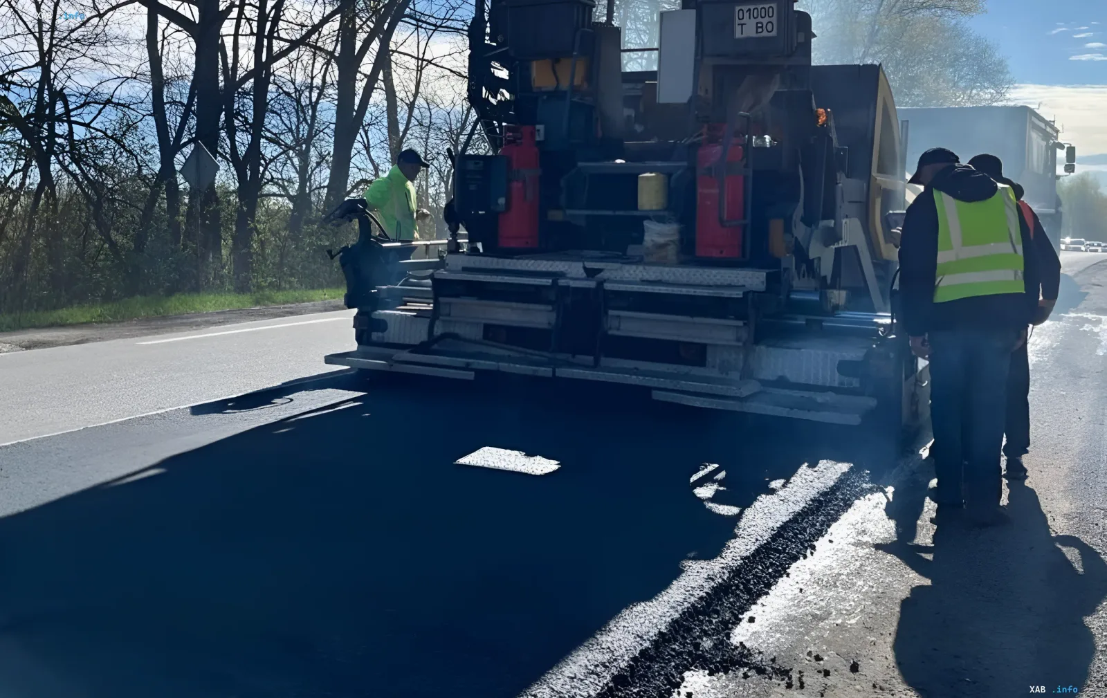 Spezialmaschinen verlegen frischen Asphalt auf einer ukrainischen Autobahn und veranschaulichen die massiven Straßenreparaturen während des Krieges.
