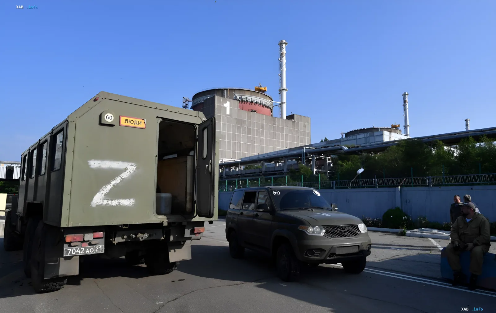 Militärlastwagen mit 'Z'-Markierung vor dem Gebäude des Kernkraftwerks Saporischschja im Hintergrund des Reaktors
