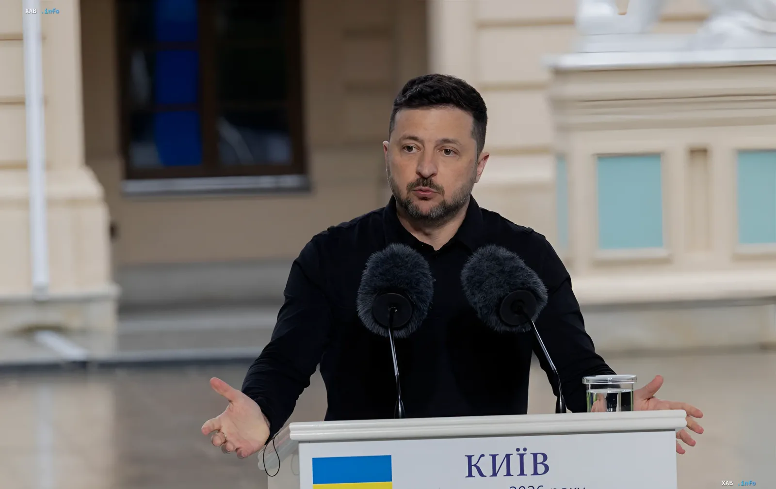 Ukrainian President Volodymyr Zelenskyy speaks at a podium with the Ukrainian flag, discussing Ukraine's NATO accession and its benefits even for Russia
