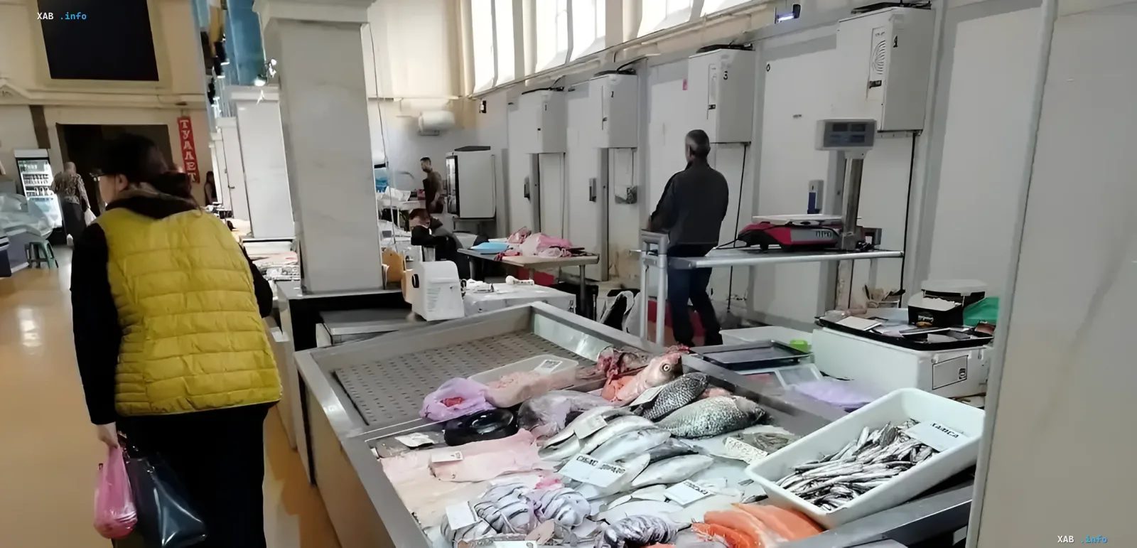 Рыбный ряд на Новом базаре Одессы: свежие морепродукты на льду, покупательница в желтом жилете выбирает рыбу