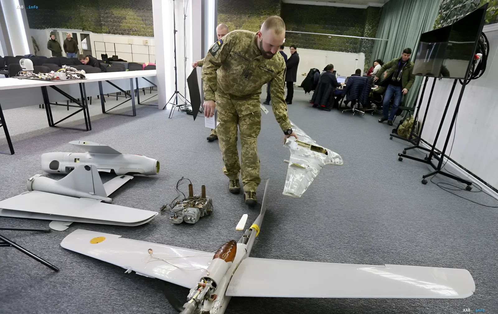 Украинский военный осматривает обломки беспилотника на выставке военной техники, иллюстрируя тему санкций ЕС против китайских поставщиков для российской армии