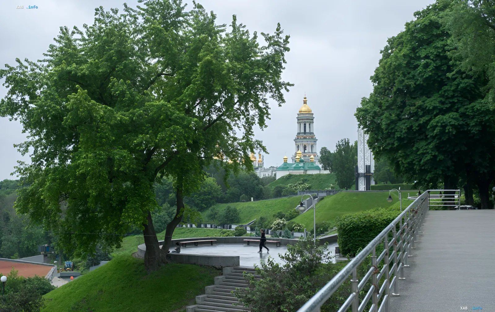 Парк в Киеве под пасмурным небом 5 июня: зеленые деревья, золотые купола собора и влажная дорожка после грозы