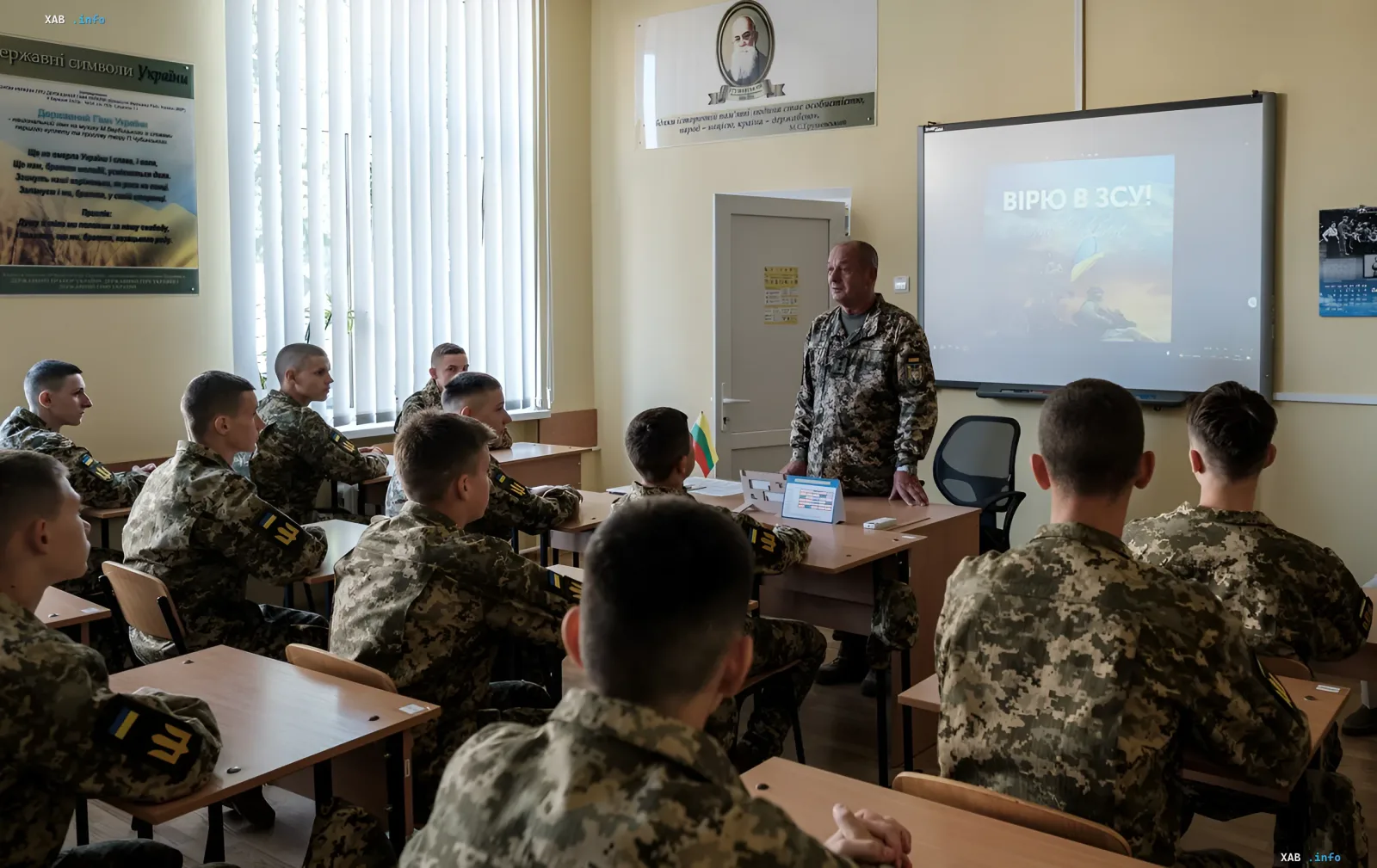Vorlesung an einer ukrainischen Militärahochschule: Offizier unterrichtet Kadetten, Bildschirm zeigt 'ICH GLAUBE AN DIE UKRAINISCHEN STREITKRÄFTE!'