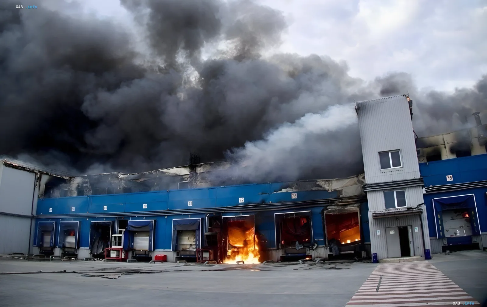 Feuer im Hauptverteilzentrum von ATB in Dnipro: Flammen brechen aus den Lagerhallentoren aus, dicker schwarzer Rauch füllt den Himmel