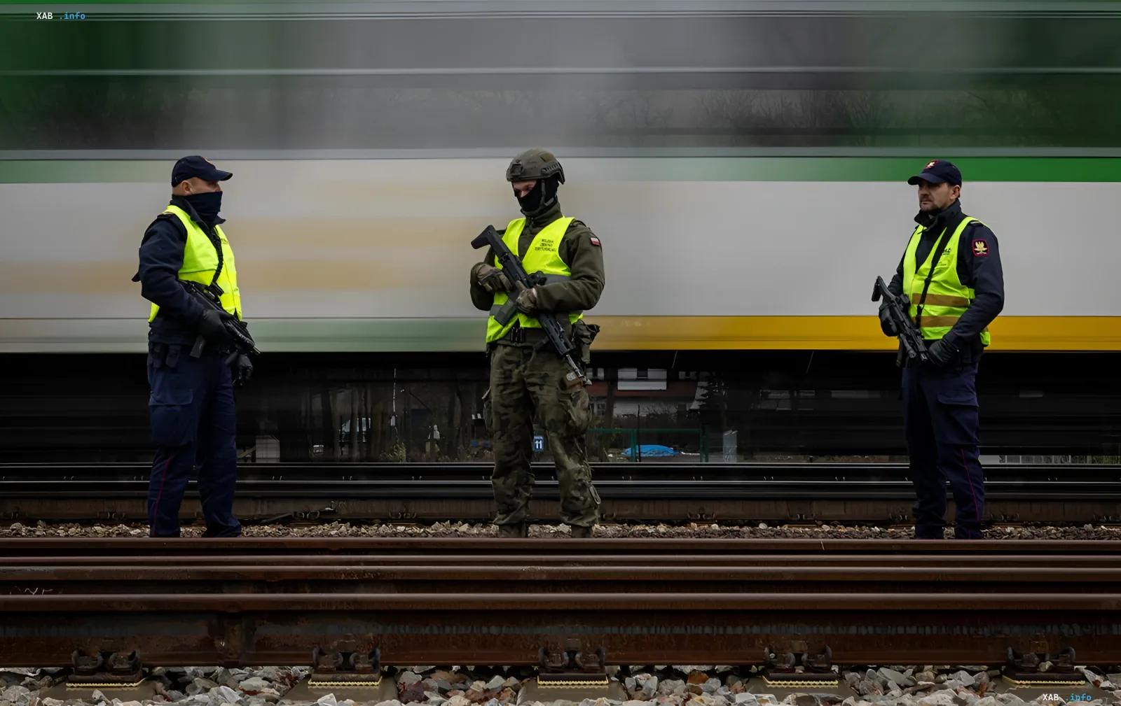 Bewaffnete Grenzbeamte und Soldaten in gelben Westen stehen auf Eisenbahnschienen in Polen und sichern die Sicherheit im Zusammenhang mit der Abschiebung eines Ukrainers wegen Wilderei