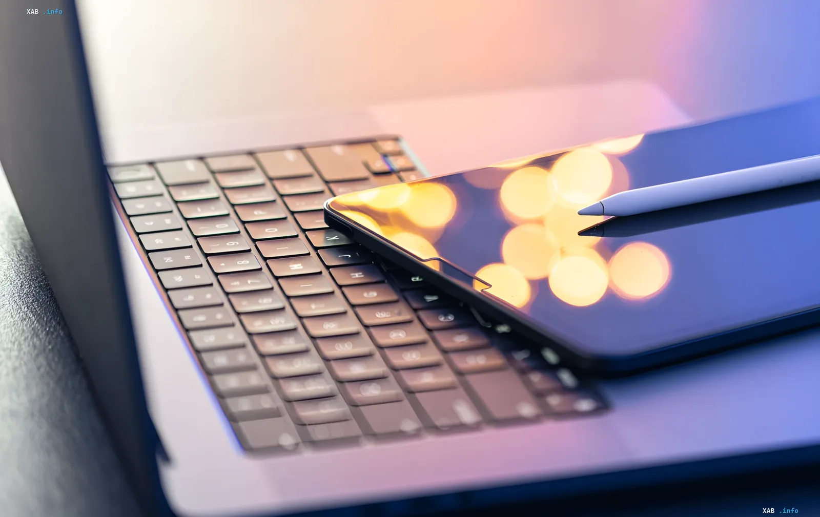 Smartphone with blurred glowing screen and stylus on laptop keyboard — symbol of blogger working with Meta’s AI tools for lip-sync automation