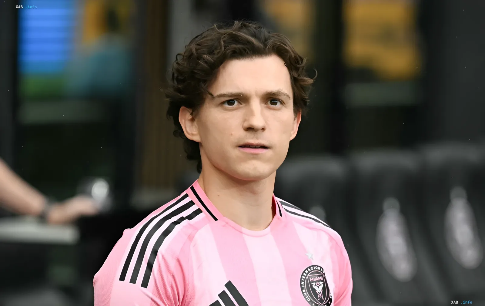 Том Холланд в розовой футболке с логотипом Inter Miami, символизирующий его выбор между «Человеком-пауком» и «Одиссеей» Кристофера Нолана.