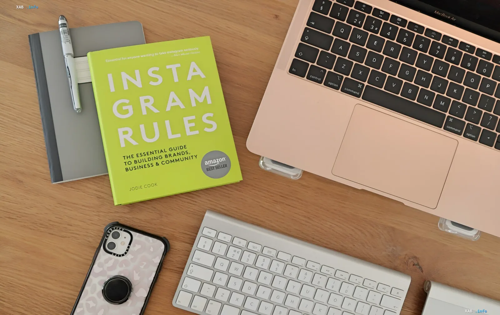 Content creator’s workspace with Instagram Rules book, laptop and phone — metaphor for AI-powered social media content creation via Ukrainian platform ooltima